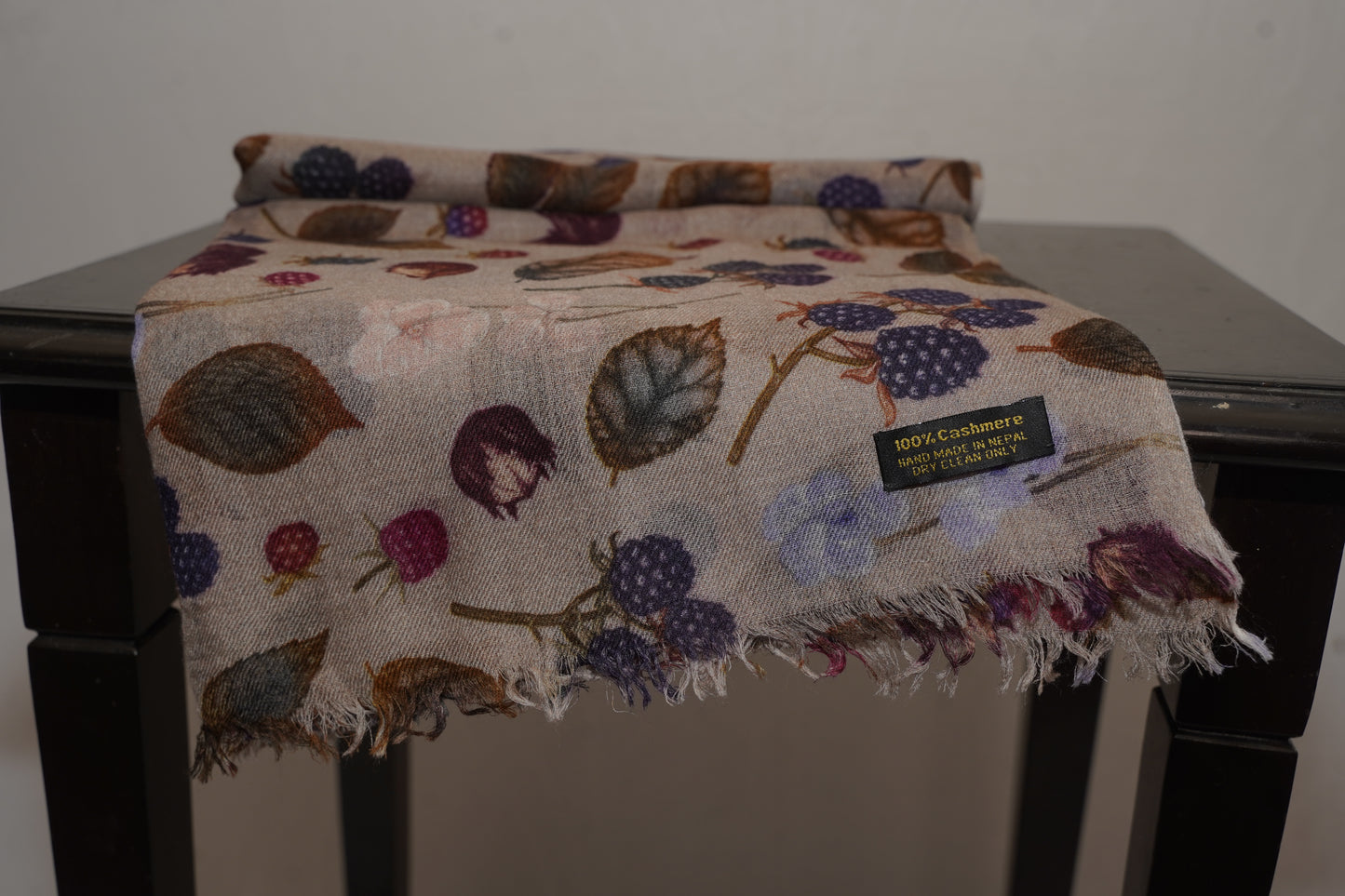 Soft women’s wrap featuring berries, flowers, and leaves on a beige background