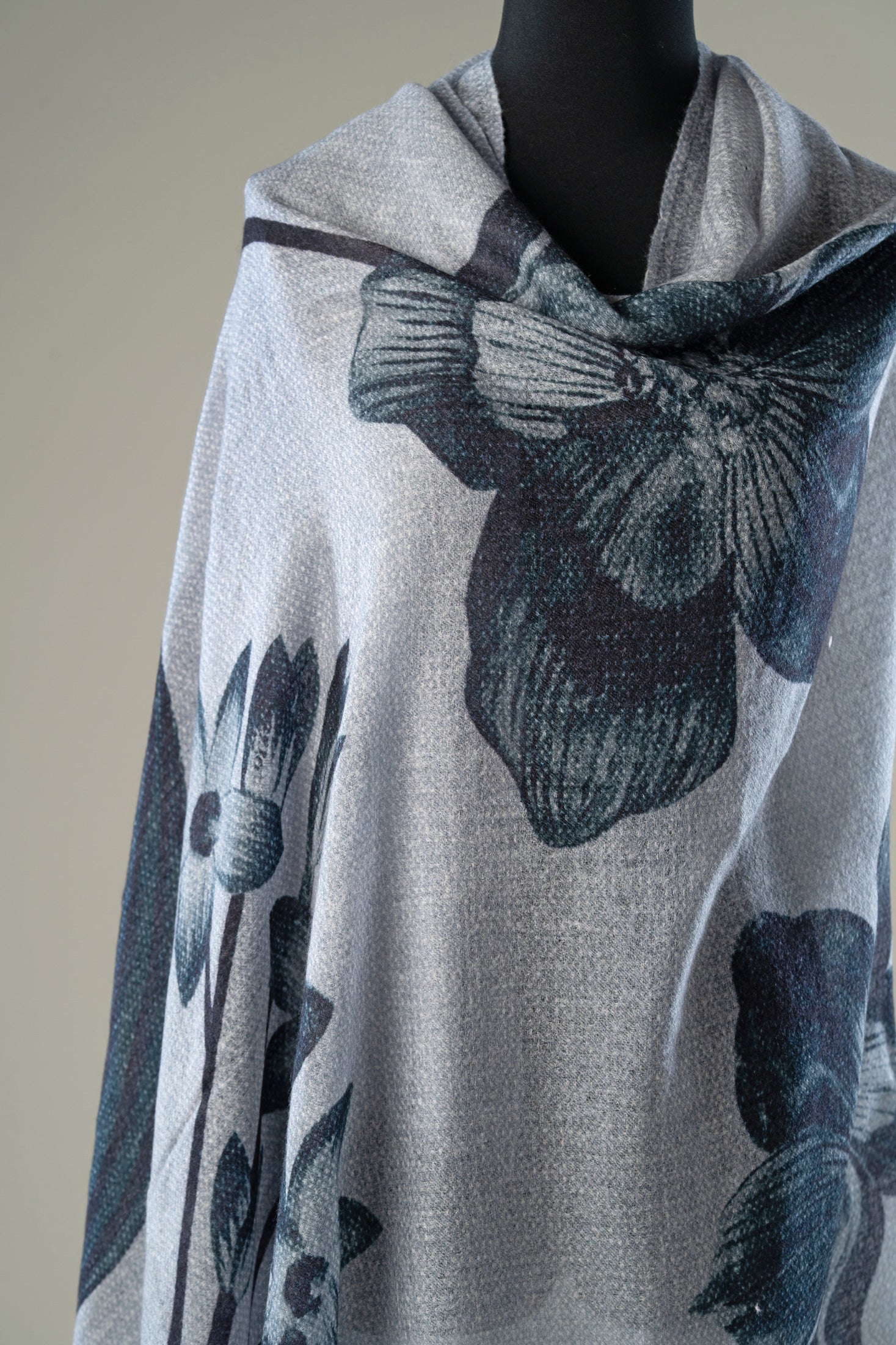 A light gray shawl with a dark blue-gray floral pattern.
