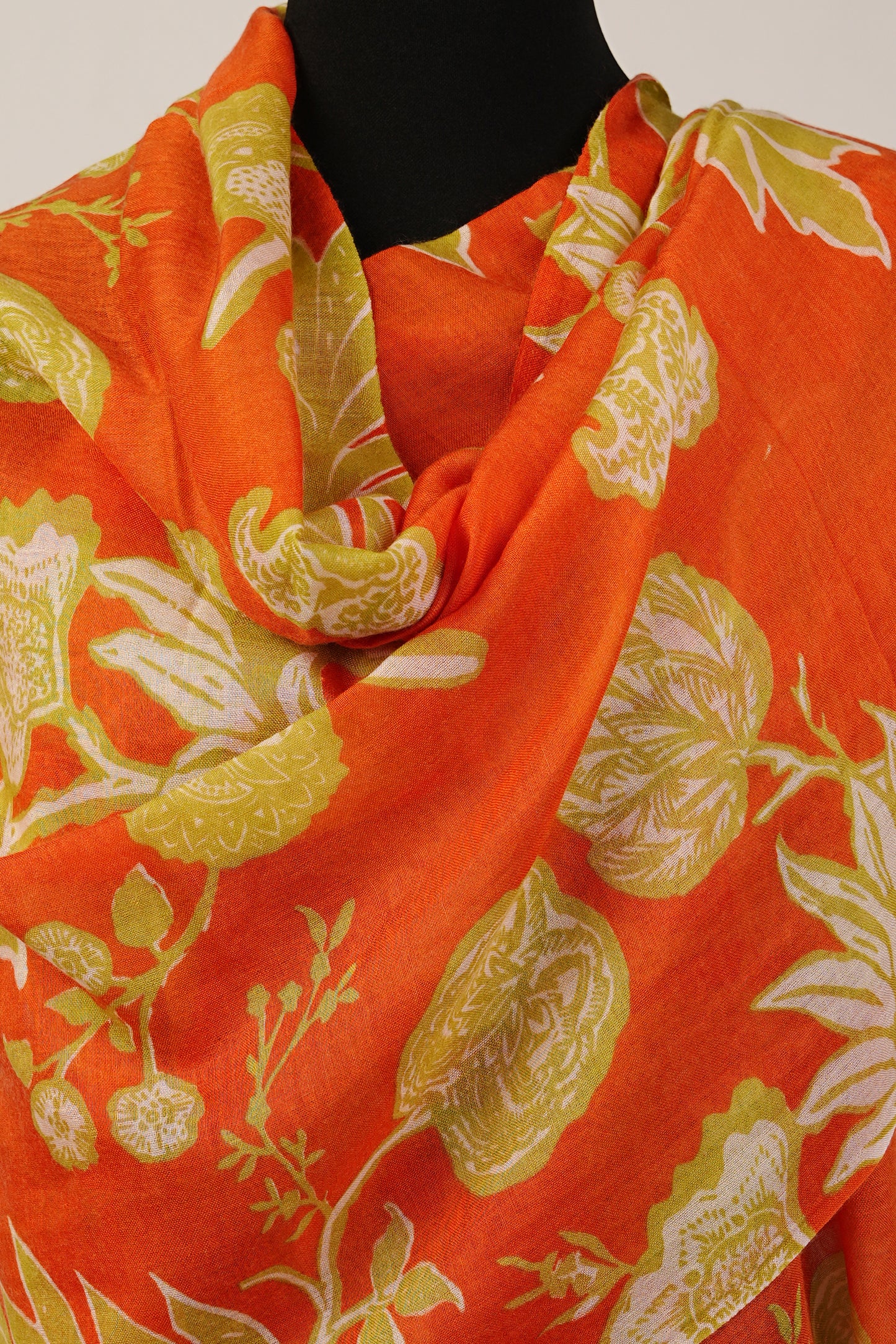 The stole is a brilliant combination of tiger orange and floral print, made from luxurious cashmere and silk.