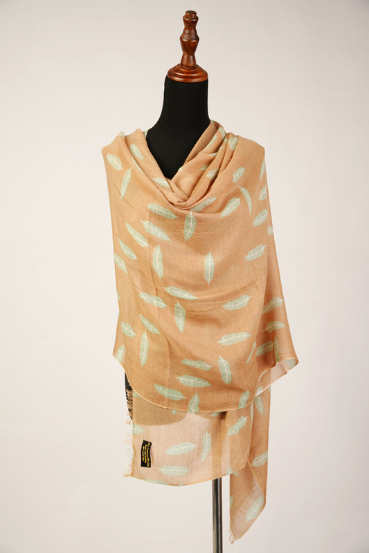 The enchanting Cashmere silk shawl features a printed image of autumn leaves gracefully descending in the cozy hues of camel brown.